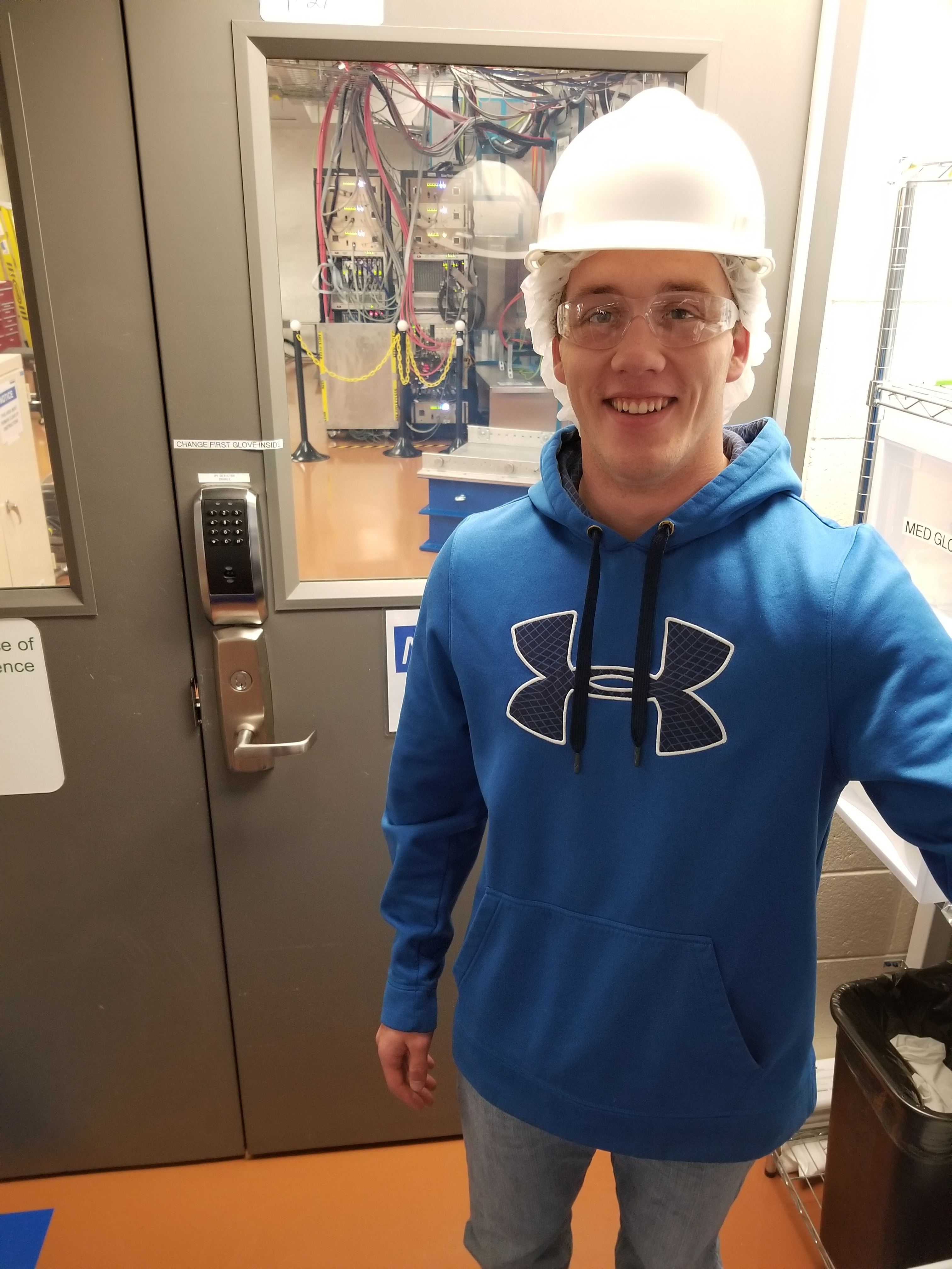 Brady Bos smiles in front of the Majorana Cleanroom space