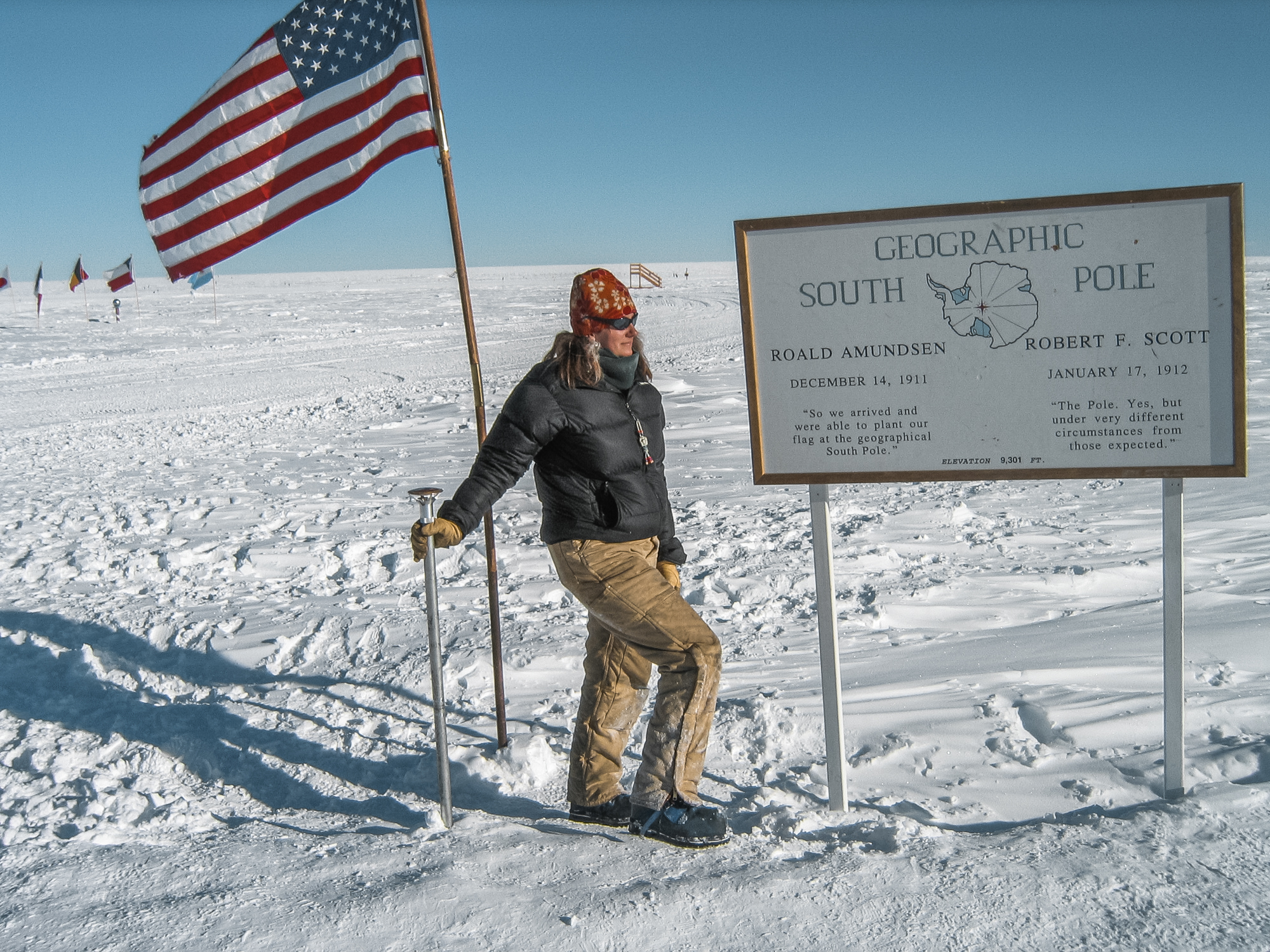 Thompson stands at the marker for the geographic South Pole
