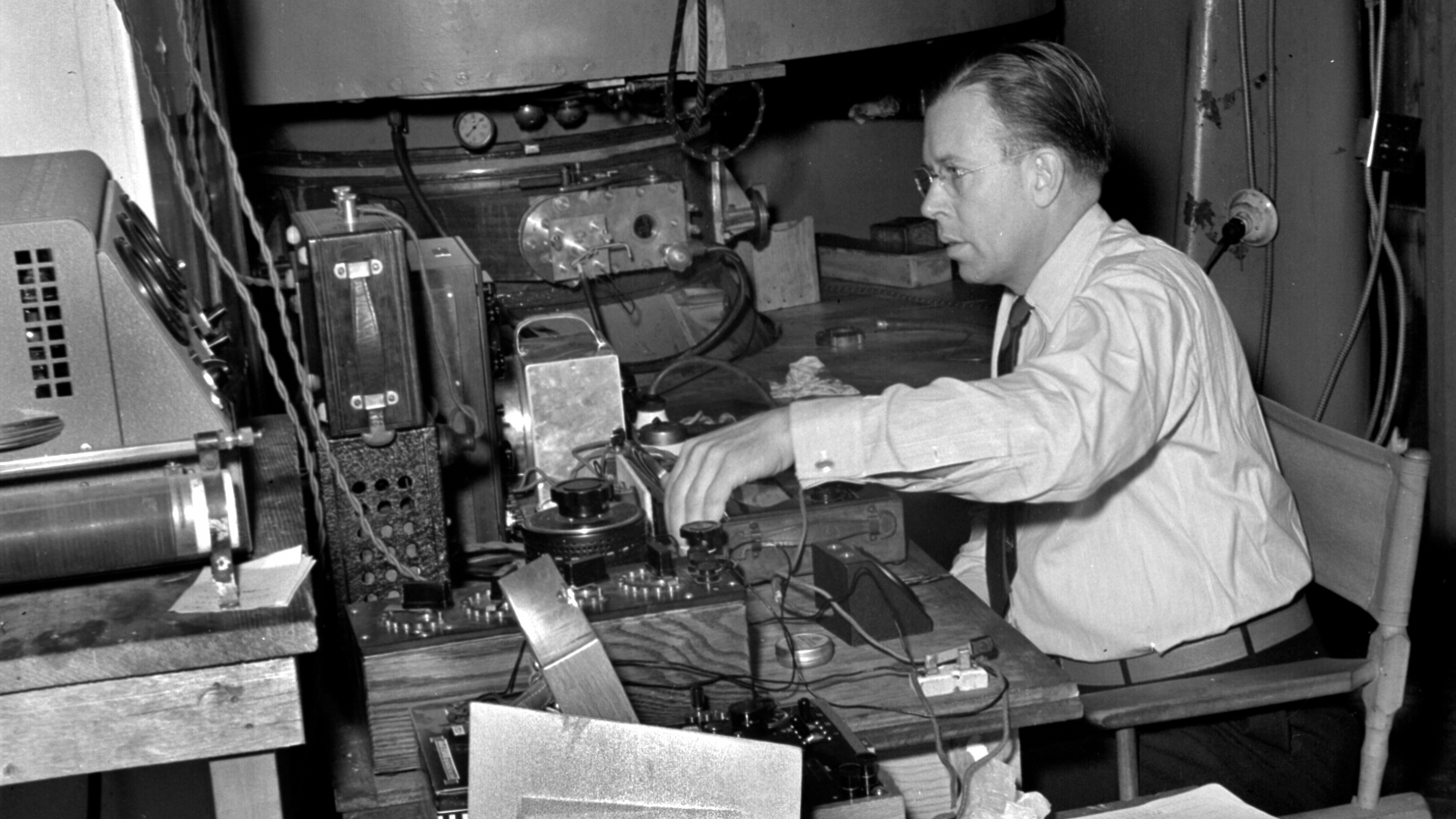 Ernest O. Lawrence sitting at equipment of 37-inch cyclotron