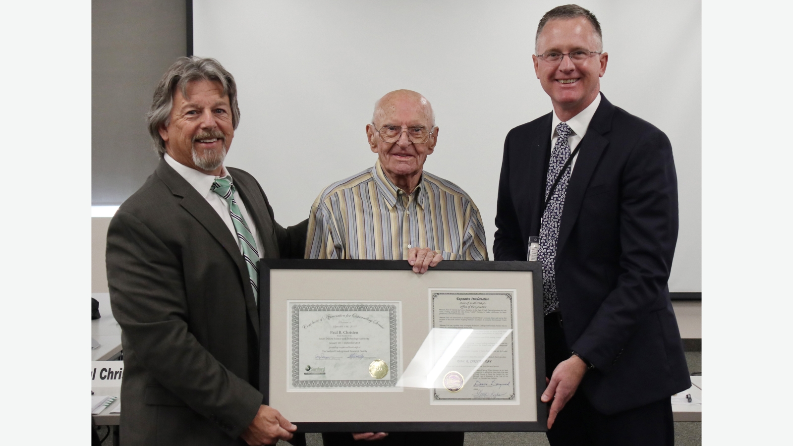 Casey Peterson, chair of the SDSTA, and Mike Headley, executive director of the SDSTA, present Paul Christen, resigning board member with a certificate of service and a proclamation from the Governor’s office declaring September 18, 2018 “Paul R. Christen Day” during the regular quarterly Board meeting.