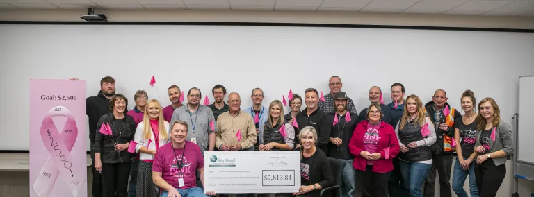 staff dressed in pink during a check presentation