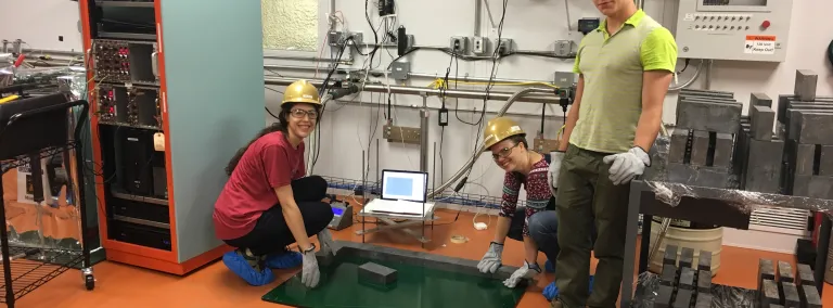 Three students build a low-background counter.