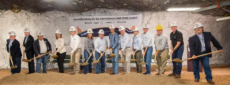 14 people with shovels break ground on a new experiment.