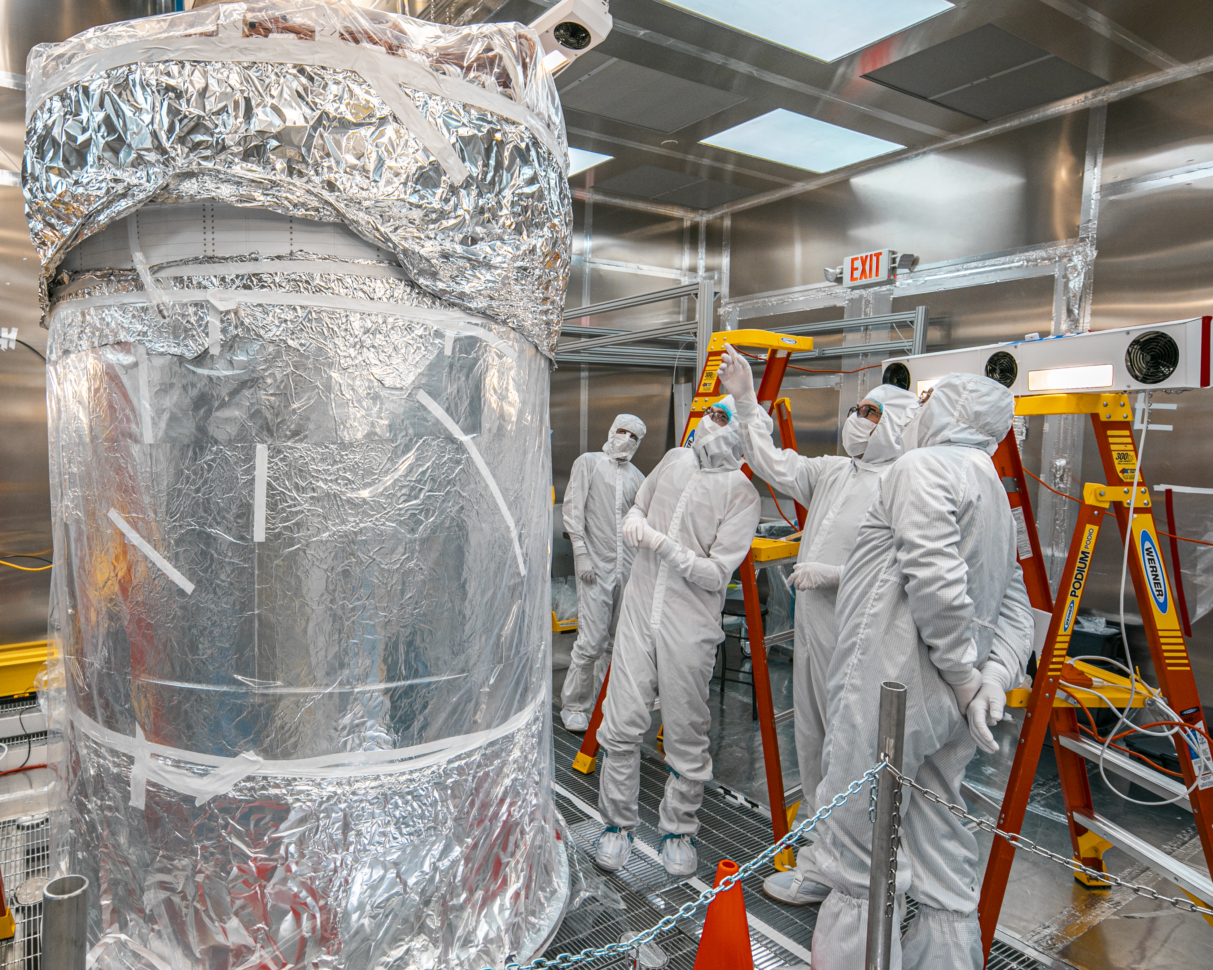 physicists in clean suits examine an inner dark matter detector