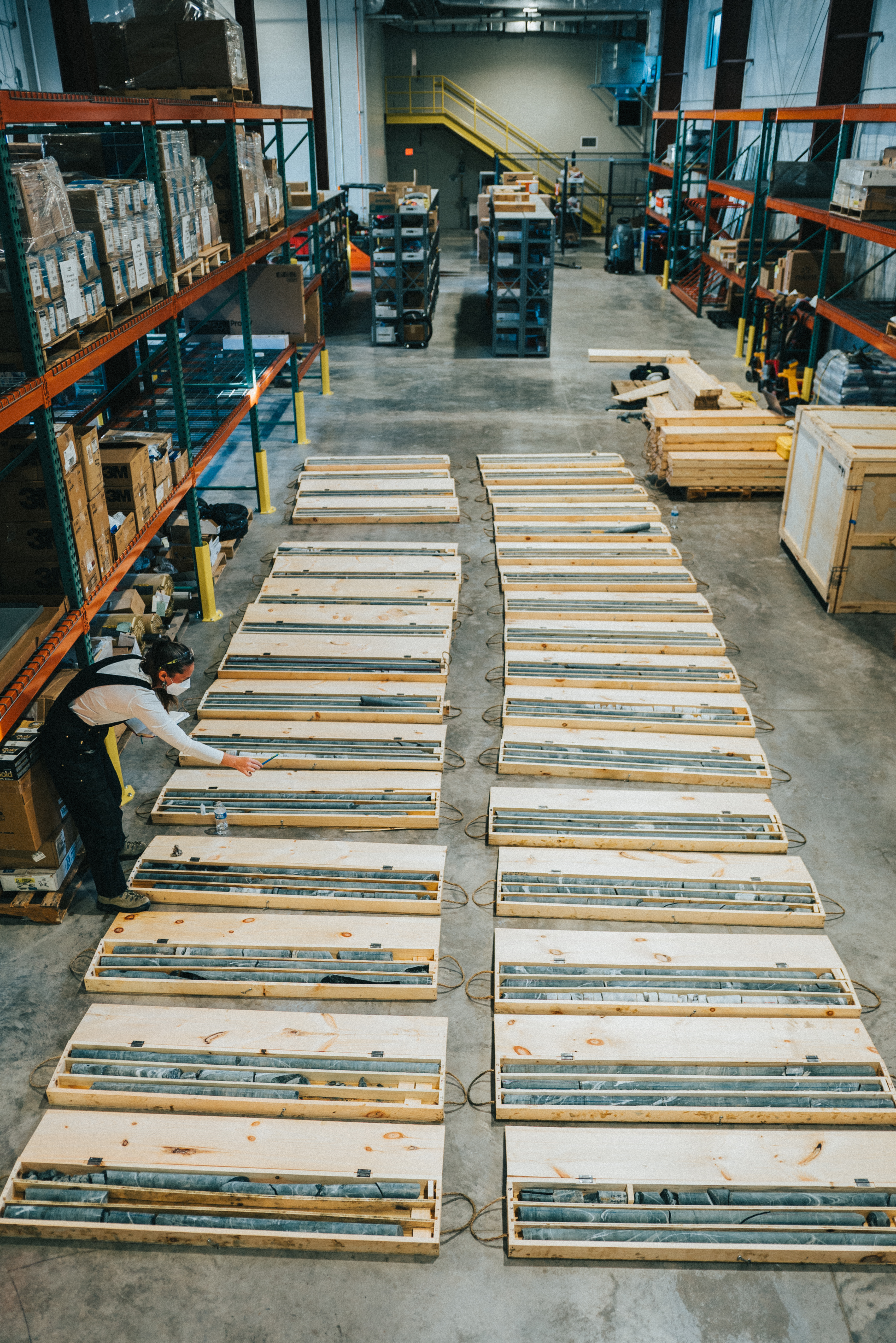 two columns of core sample boxes are laid on the floor of the warehouse