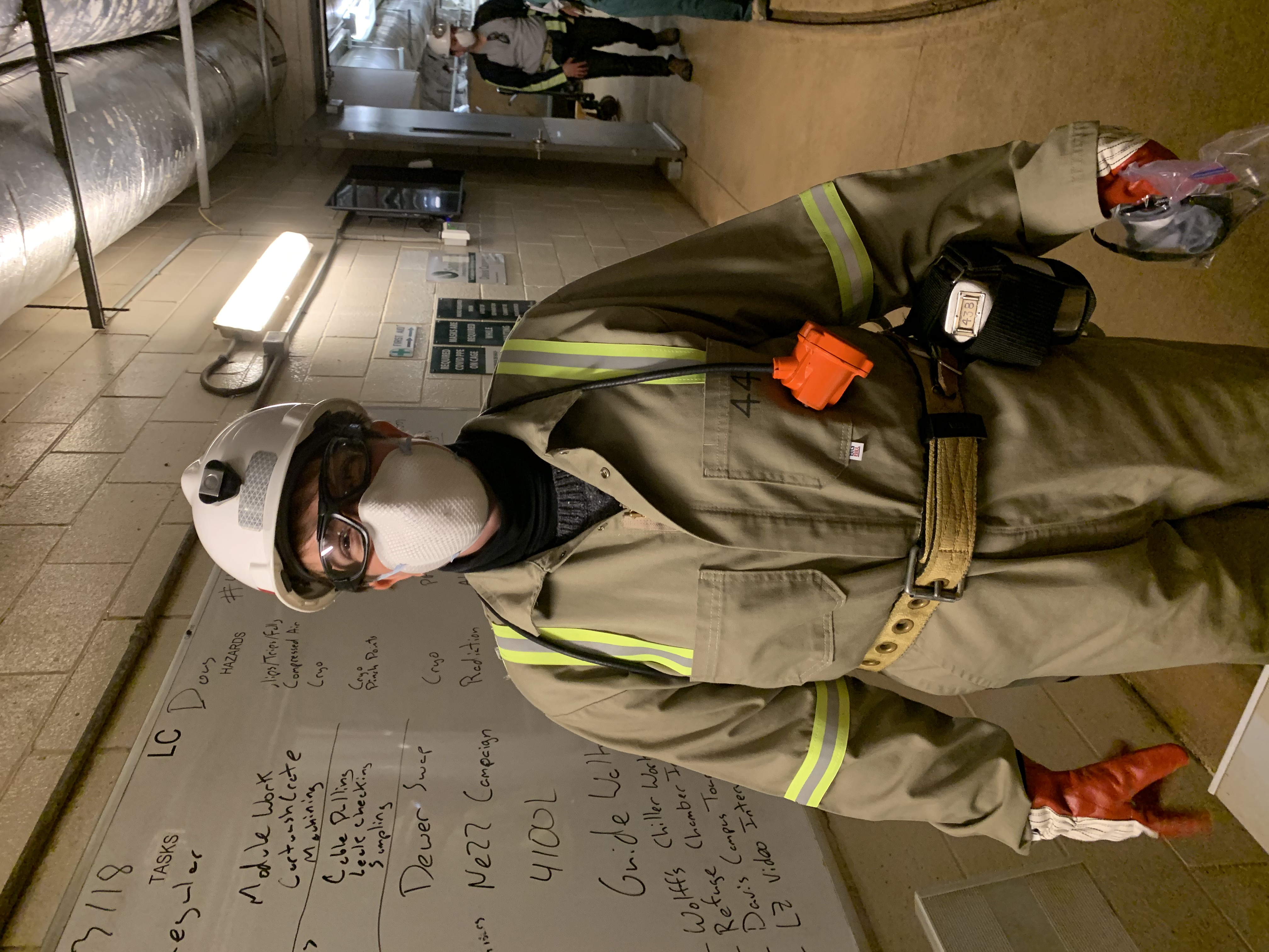 photo of a person in an underground drift with a hardhat, mask and safety glasses