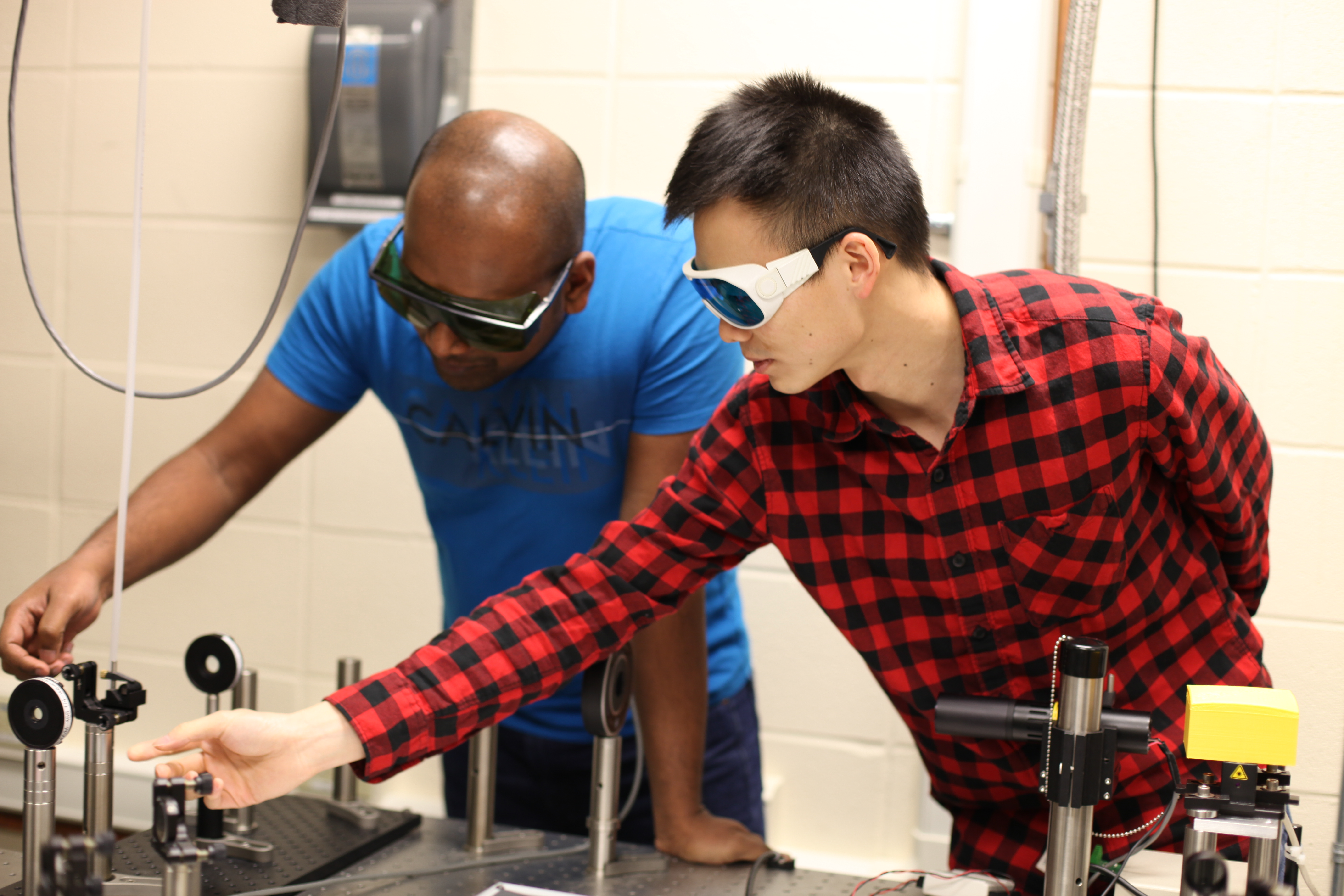 SD Mines students Ishara Ratnayake and Lin Kang work with Smith to develop laser physics technologies.