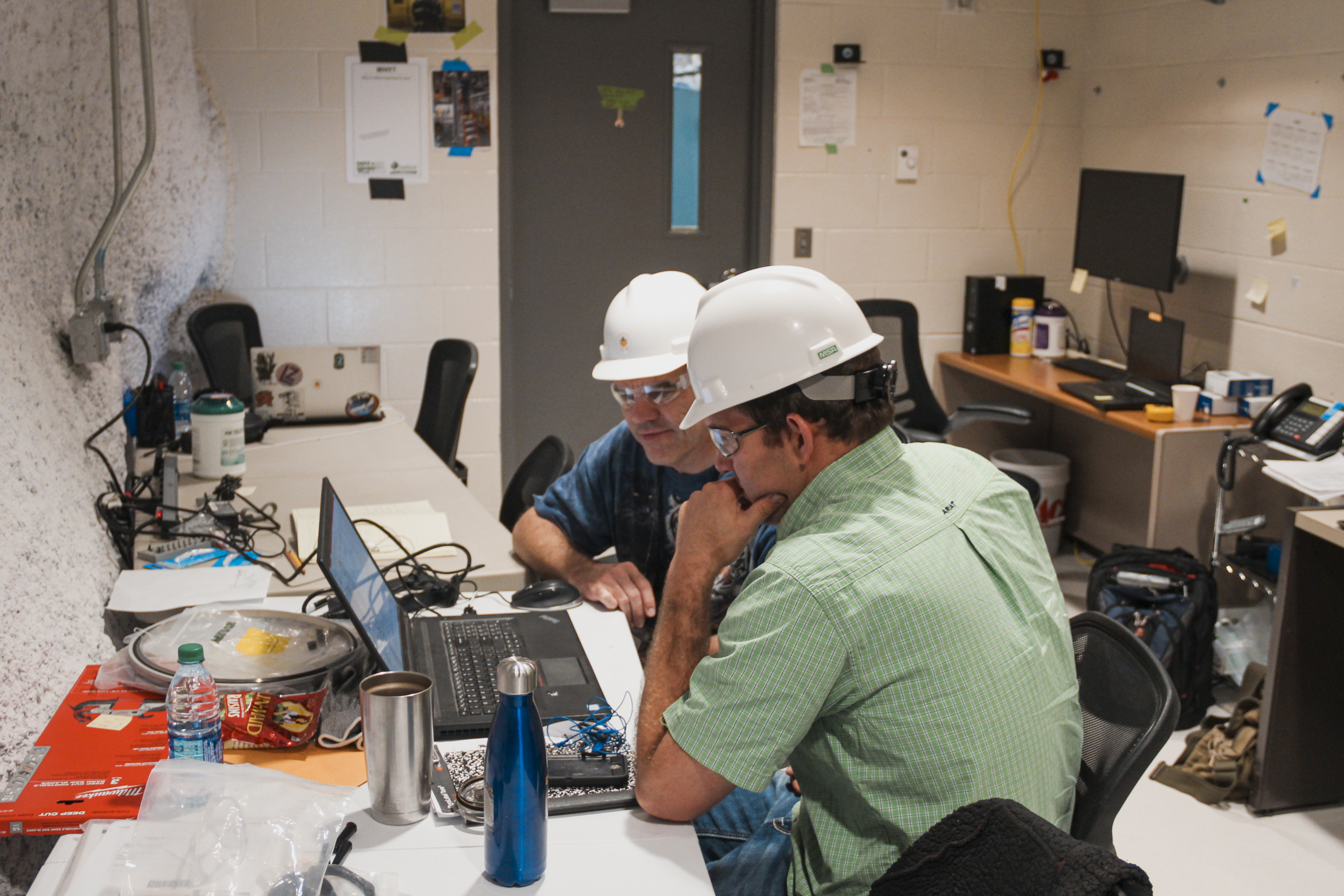 Two people look at a computer