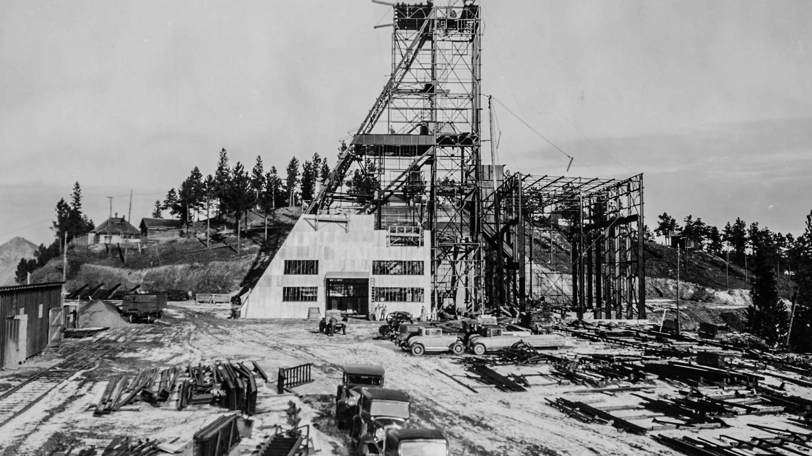 a black and white photo of early construction of a headframe