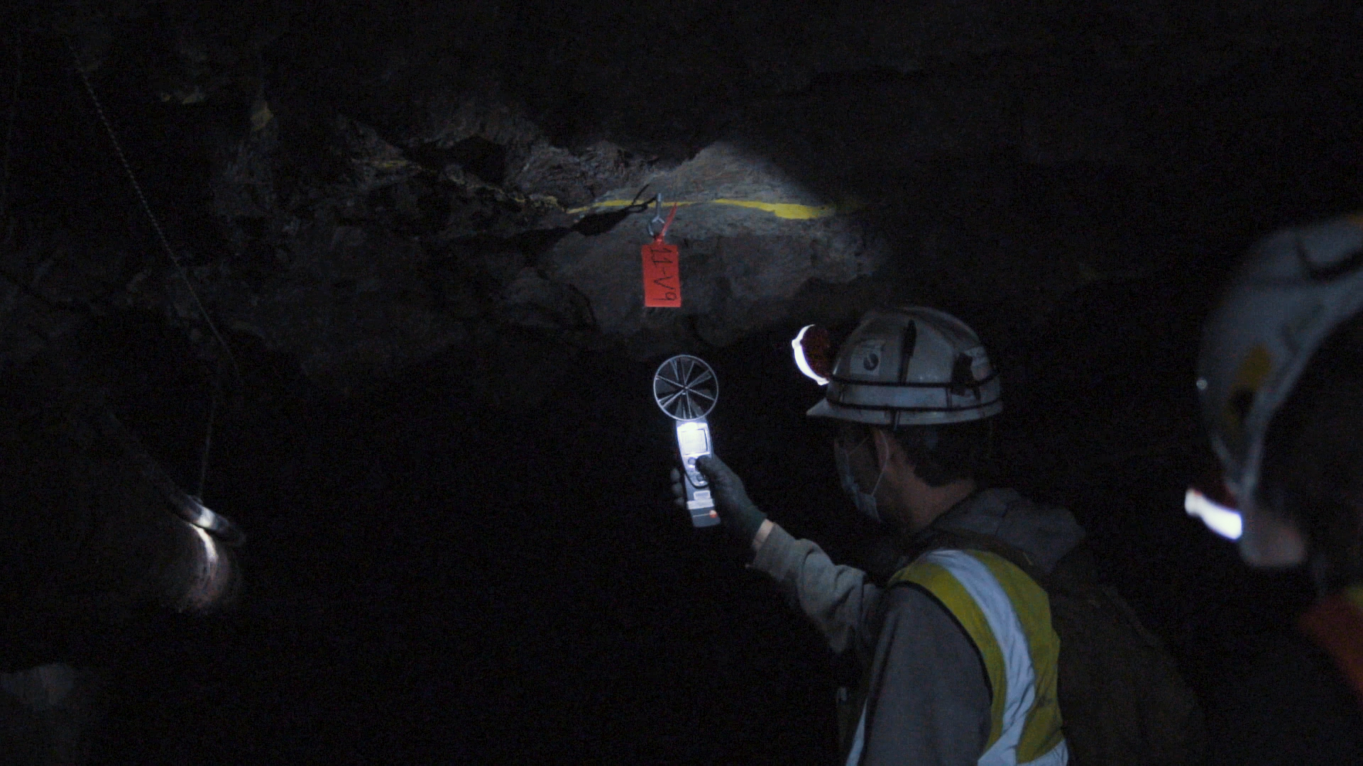 a person holds an airflow meter in a drift