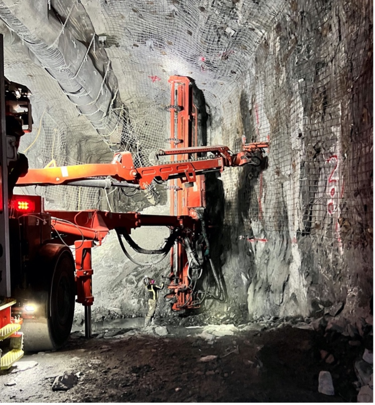 A construction miner stands near a bolter, a huge machine that installs 20-foot-long rock bolts in the caverns that will house the Deep Underground Neutrino Experiment. About 16,000 bolts will need to be installed to provide ground support in the gigantic, seven-story-tall caverns a mile underground. Photo: Jason Hogan, Thyssen Mining Inc.