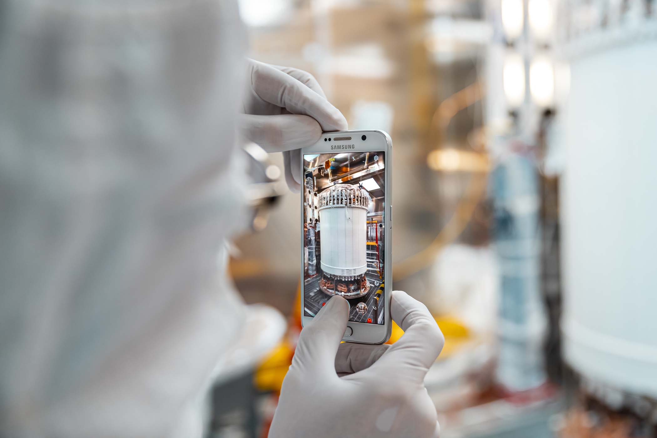 A researcher snaps a photograph of the recently assembled LUX-ZEPLIN xenon detector in the Surface Assembly Lab cleanroom at Sanford Underground Research Facility on July 26, 2019. Photo by Nick Hubbard, Sanford Underground Research Facility.