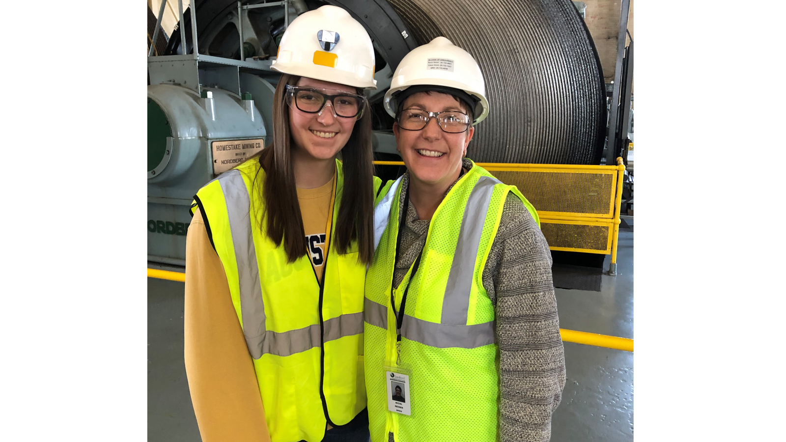 two people. in hardhats smile in the hoistroom