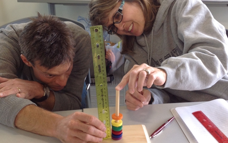 Teachers measure the distance between levitating magnets.