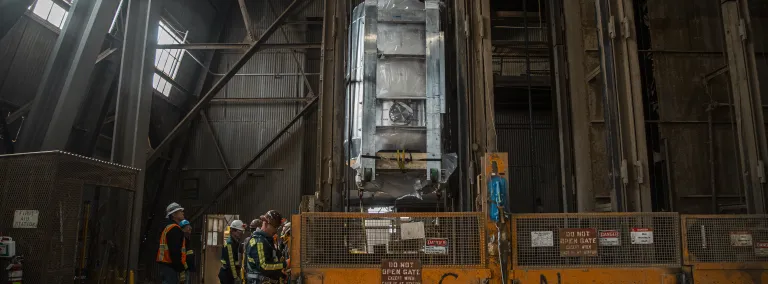 The LZ detector hangs suspended beneath the Yates Cage, with workers to the left.