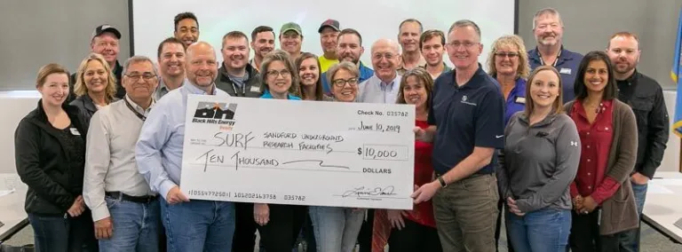 Black Hills Energy presents Sanford Underground Research Facility with a $10,000 check to sponsor Neutrino Day 2019.