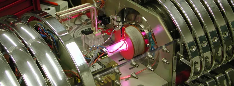 Hydrogen plasma glows at the ion source of the LUNA accelerator. The plasma is needed to extract and accelerate protons.