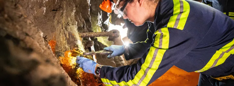 a scientists retrieves biologic samples from underground