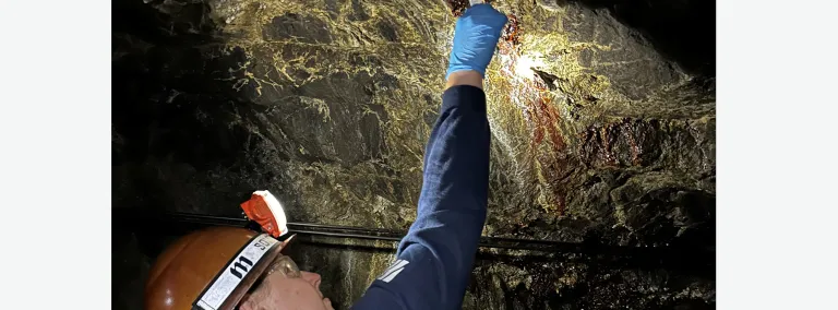 Regan DeBoer, a senior studying geology at South Dakota Mines takes a water sample at SURF. 