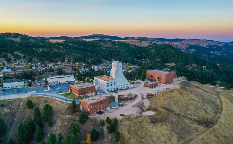 a shot from the sky of the Yates headframe and the SURF admin building and other structures in the sunrise on a fall morning. 