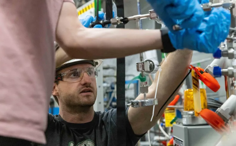 Scientists working on LZ complete hands-on tasks needed to make the experiment run, they are weating rubber gloves and PPE.