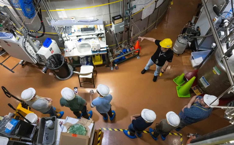 a shot from above showing individuals in hard hats and PPE viewing the LZ experiment