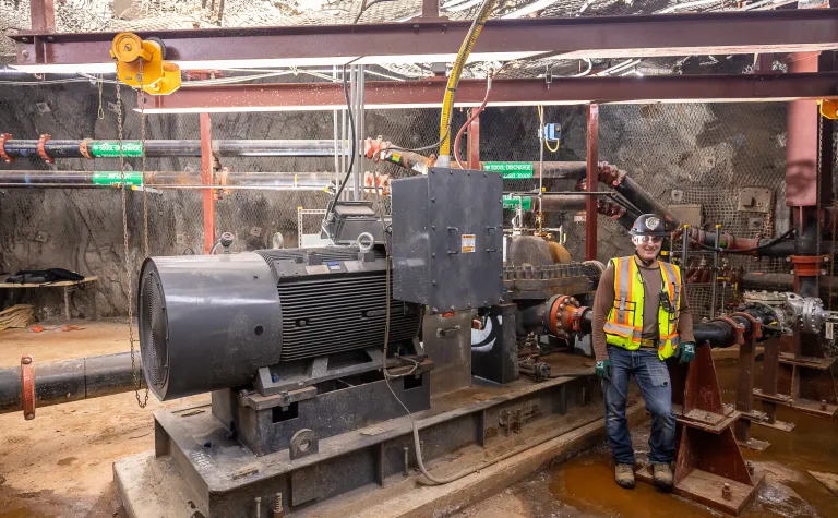 Andrew Brosnahan, a professional engineer at SURF, and one member of the team that updated the 3650 pump room, poses near the new pump.