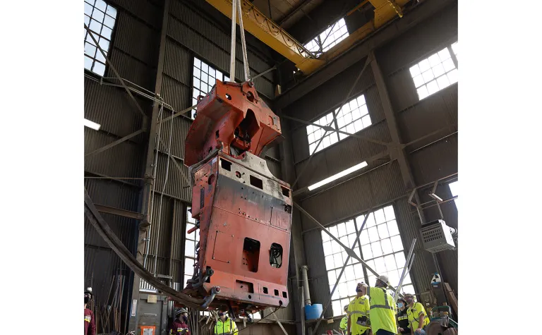 A large piece of equipment hanging from a crane inside the headfram at SURF. 