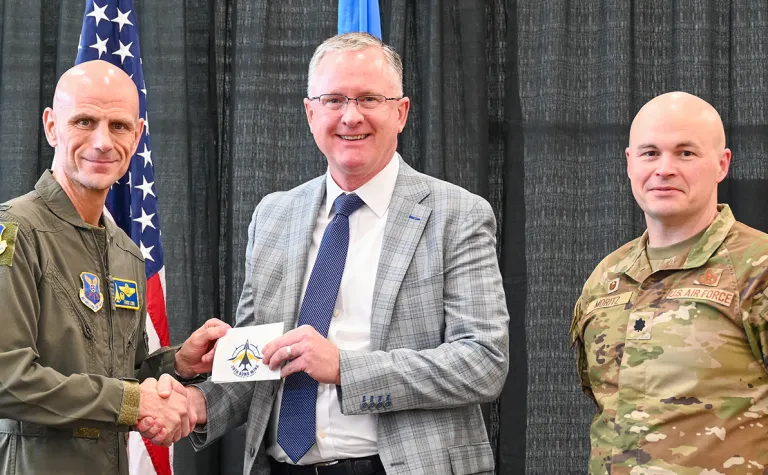During a luncheon recognizing the new Honorary Commanders at Ellsworth, Col. Erick D. Lord, 28th Bomb Wing commander shakes hands with Mike Headley, SDSTA Executive Director and SURF Laboratory Director. Lt. Col. Daniel J. Moritz, 28th Logistics Readiness Squadron commander, who will be working with Headley during the program, stands alongside. Airman 1st Class Cameron B. Williams / Ellsworth Air Force Base