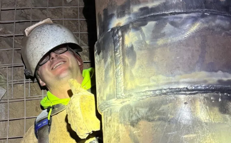 King Brown, a hoist operator at SURF who is also a certified pipe welder standing next to his work. 