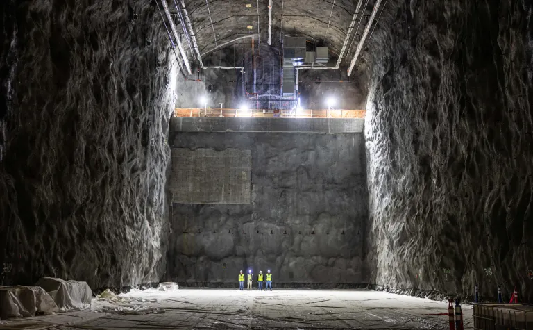Four individuals standing inside the DUNE Cavern--the massive size of the cavern dwarfs the people -- giving scale. 