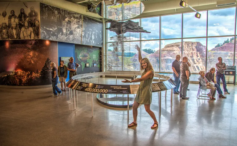 Billi Bierle shows off the Sanford Lab Homestake visitor center exhibits.