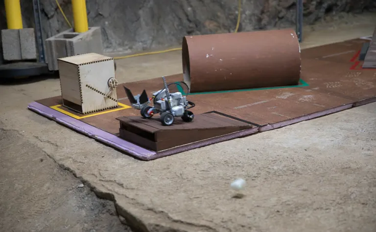 A LEGO robot tosses its payload at the end of the obstacle course