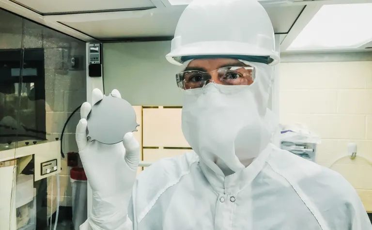 Sam Meijer, staff scientist at Los Alamos National Laboratory, holds a tantalum plate in a cleanroom on the 4850 Level of Sanford Underground Research Facility, where a new experiment is searching for  the decay of nature’s rarest isotope. Photo by Erin Lorraine Broberg 