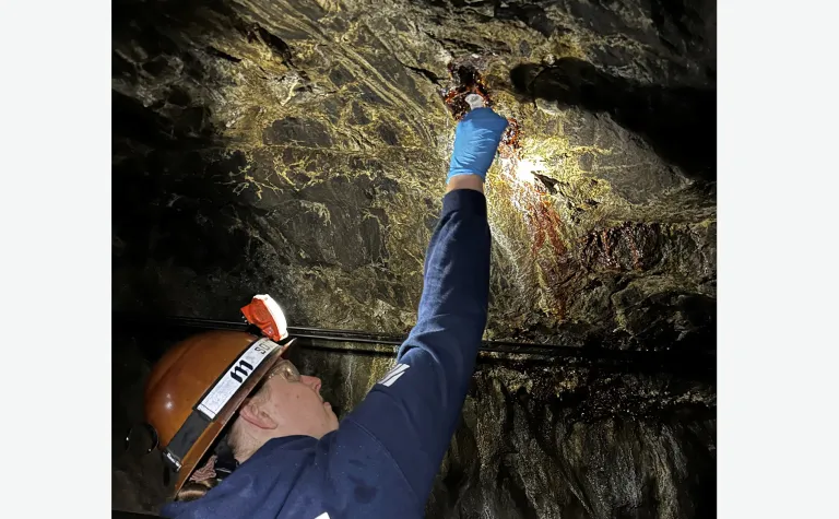 Regan DeBoer, a senior studying geology at South Dakota Mines takes a water sample at SURF. 