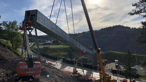 crane lowers large metal component of tramway