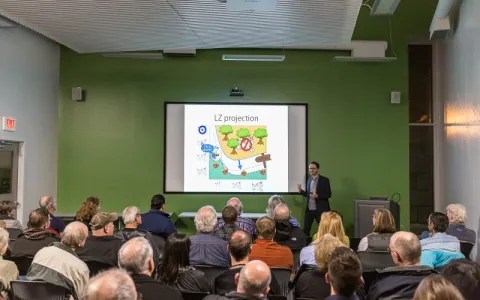 Speaker giving a talk at the Sanford Lab Homestake Visitor Center in front of a crowd ofpeople