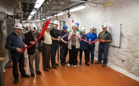 group of people doing a ribbon cutting underground