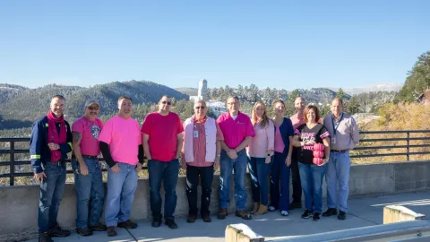 group of people wearing pink and smiling 