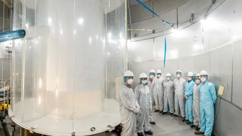 group of scientists standing inside the lux-zeplin cryostat