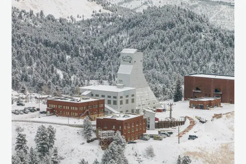 The Yates Shaft and administration buildings at the Sanford Underground Research Facility (SURF) on a cold morning surrounded in snow and frost covered trees.