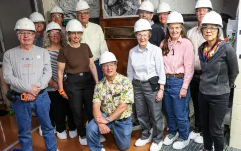 group of people in hard hats smile during 10 year anniversary of davis campus