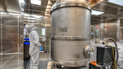 The LZ Tank a stainless steel tank with a researcher in clean room garb in a shiny steel walled room