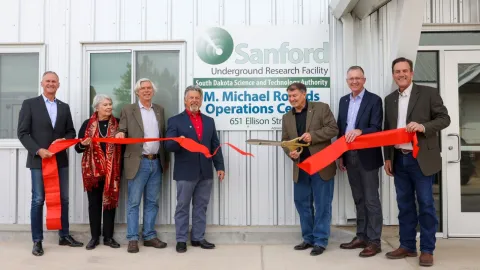 group of people cutting a ribbon for the operations center