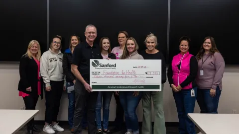 SURF employees present check to the SD Foundation of Health for Breast Cancer Awareness