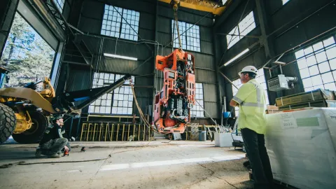 men rigging and slinging underground equipment under shaft cage