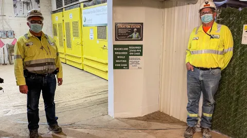 2 men stadning next to plaque 