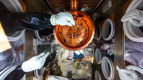 scientists assemble experiment in glovebox