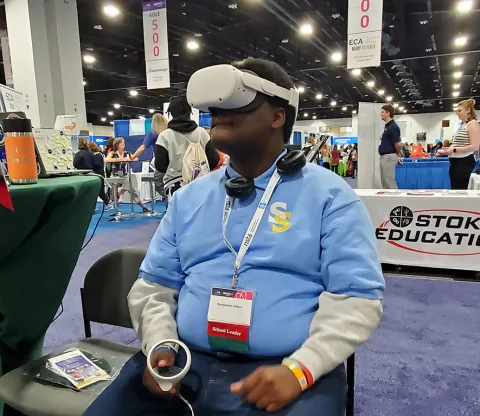 A participant at the 2024 NSTA conference views SURF's underground via in VR goggles. 