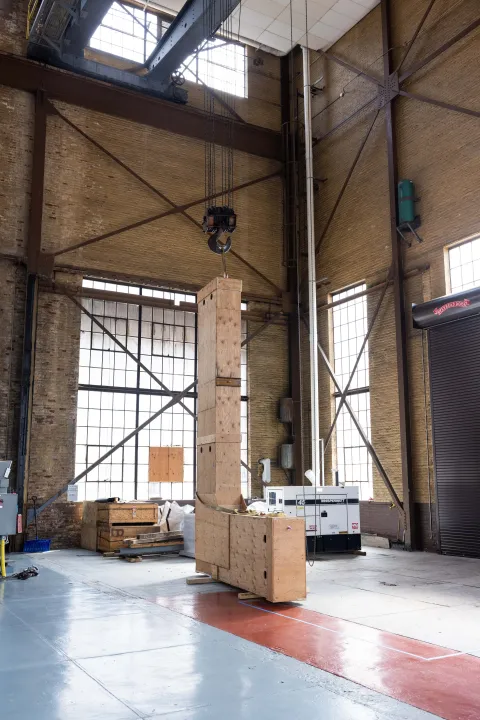 Wooden L beam in the large hoist room with windows and steel beams